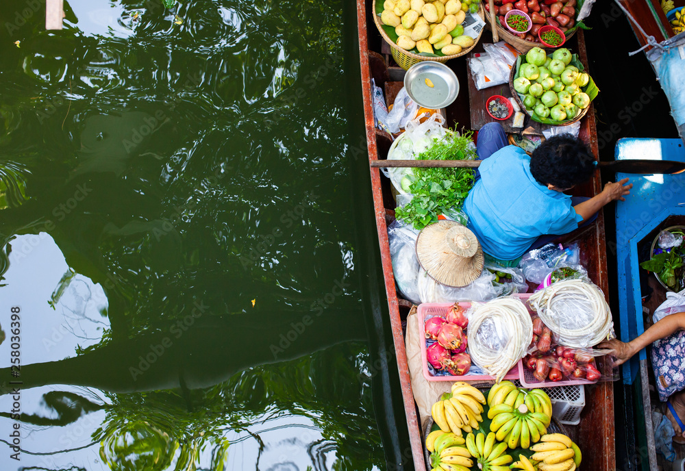 floating market - top view of boat full of fresh fruits on sale
