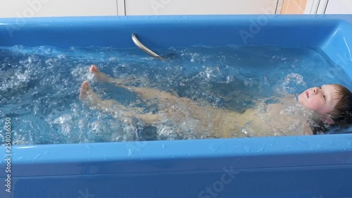 baby boy is taking a bath with bubbles. Jacuzzi bubble bath procedure.
