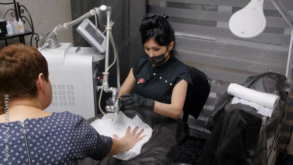 Fractional laser CO2. Cosmetic procedure.Woman having a laser skin treatment in a skincare clinic. Doctor doing a laser treatment on a woman hand. Panning shot. 4k Fractional laser CO2. Cosmetic procedure.Woman having a laser skin treatment in a skincare clinic. Doctor doing a laser treatment on a woman hand. Panning shot. 4k
