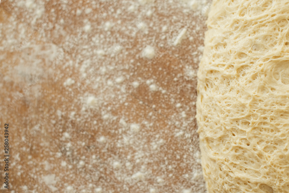 dough lying on a wooden cutting board sprinkled with flour dough lying on a wooden cutting board sprinkled with flour