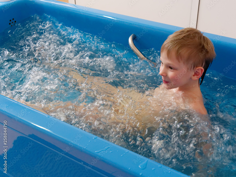 baby boy is taking a bath with bubbles. Jacuzzi bubble bath procedure ...