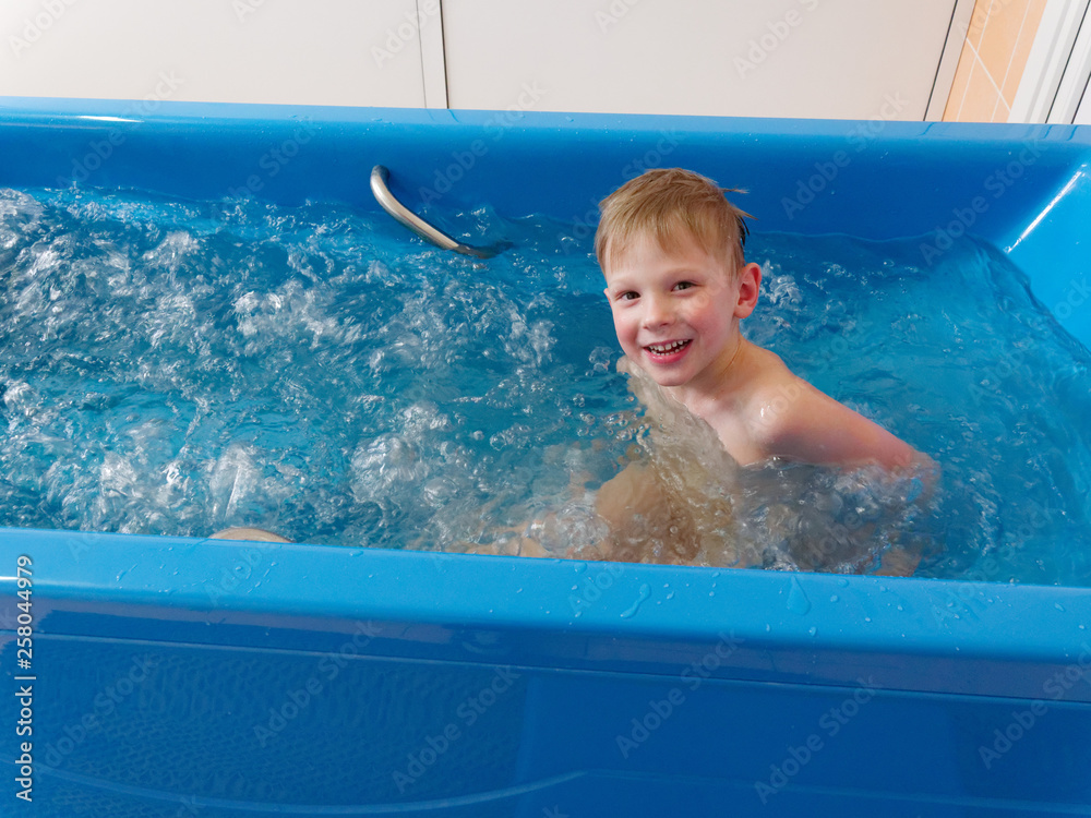 baby boy is taking a bath with bubbles. Jacuzzi bubble bath procedure