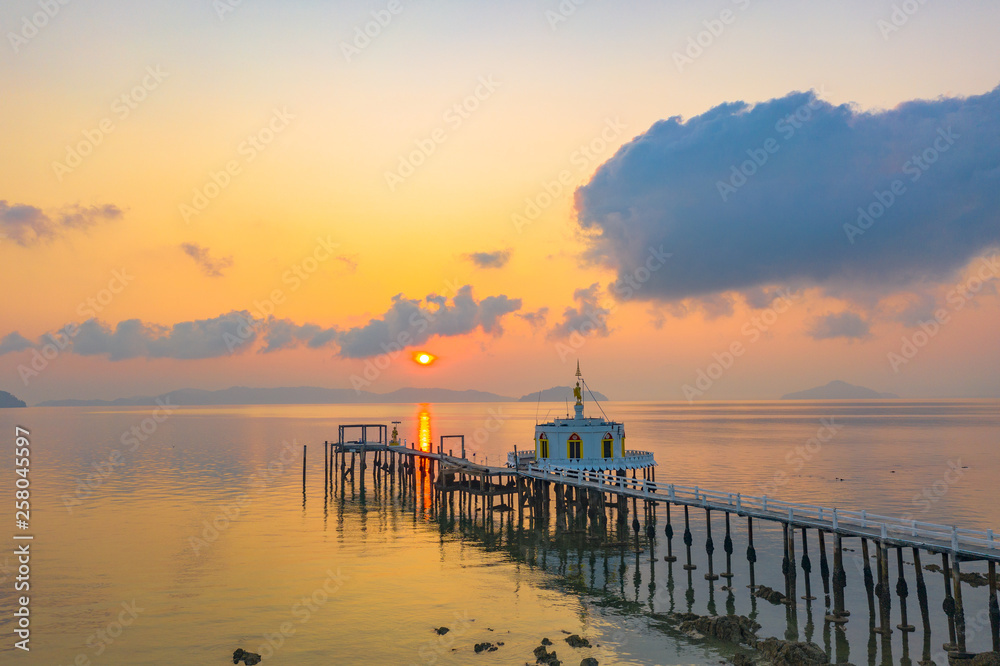 Obraz premium aerial view sunrise at pier of Phayam temple one landmark of Phayam island. Phayam temple is on Hin Kao gulf. .The temple is close to the shipping port. in the end of Phayam temple pier have memorial