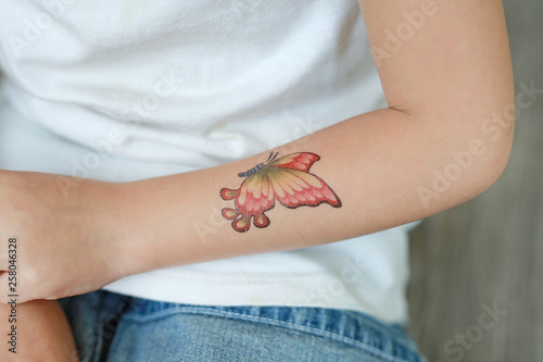 Photography Close-up little child girl with butterfly tattoo sticker on hand, Dress up tattoos
