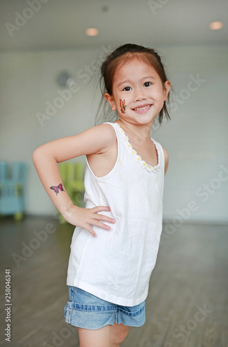 Adorable little Asian kid girl with butterfly tattoo sticker on cheek and arms, Dress up tattoos. Free Download Adorable little Asian kid girl with butterfly tattoo sticker on cheek and arms, Dress up tattoos. - GFXLoad