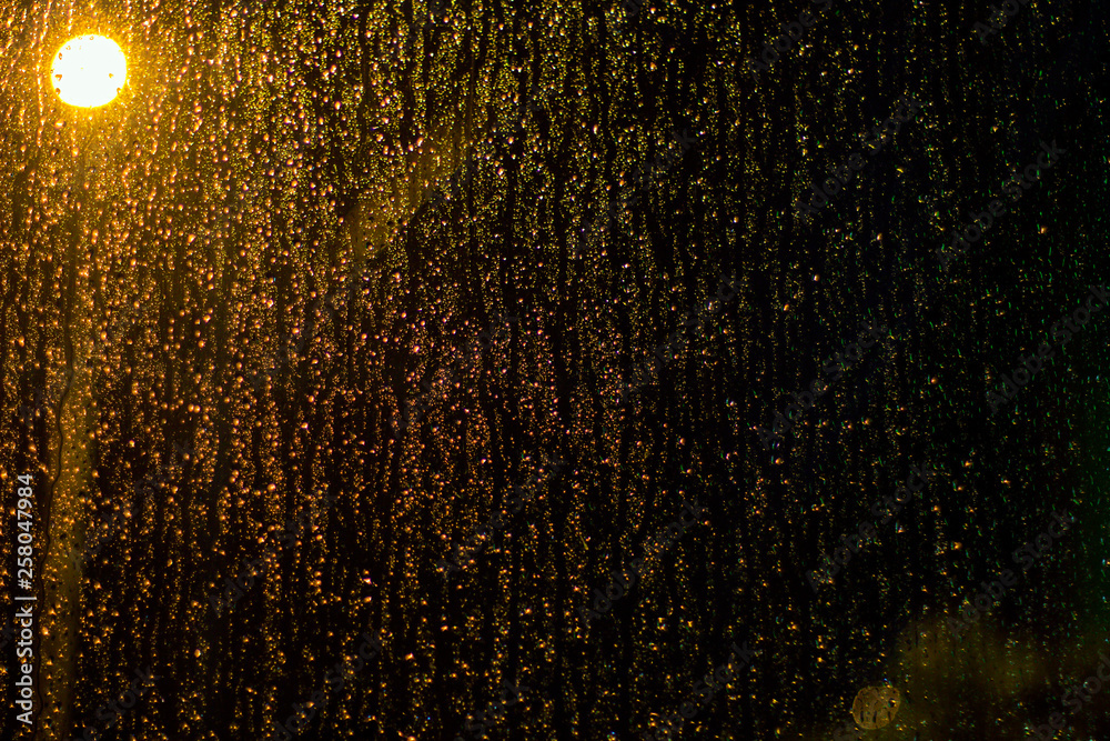 rain drops on windows with bokeh background light, street light
