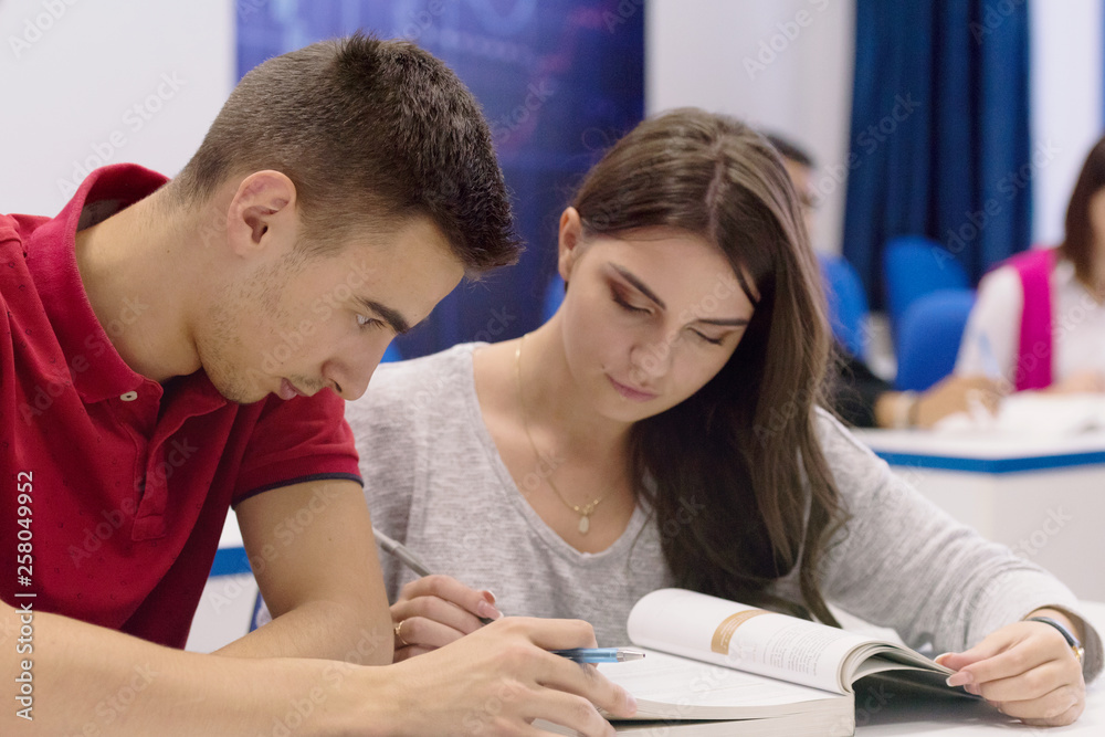 University Students during the class. Resolving problems together. Team work concept. University Students during the class. Resolving problems together. Team work concept.