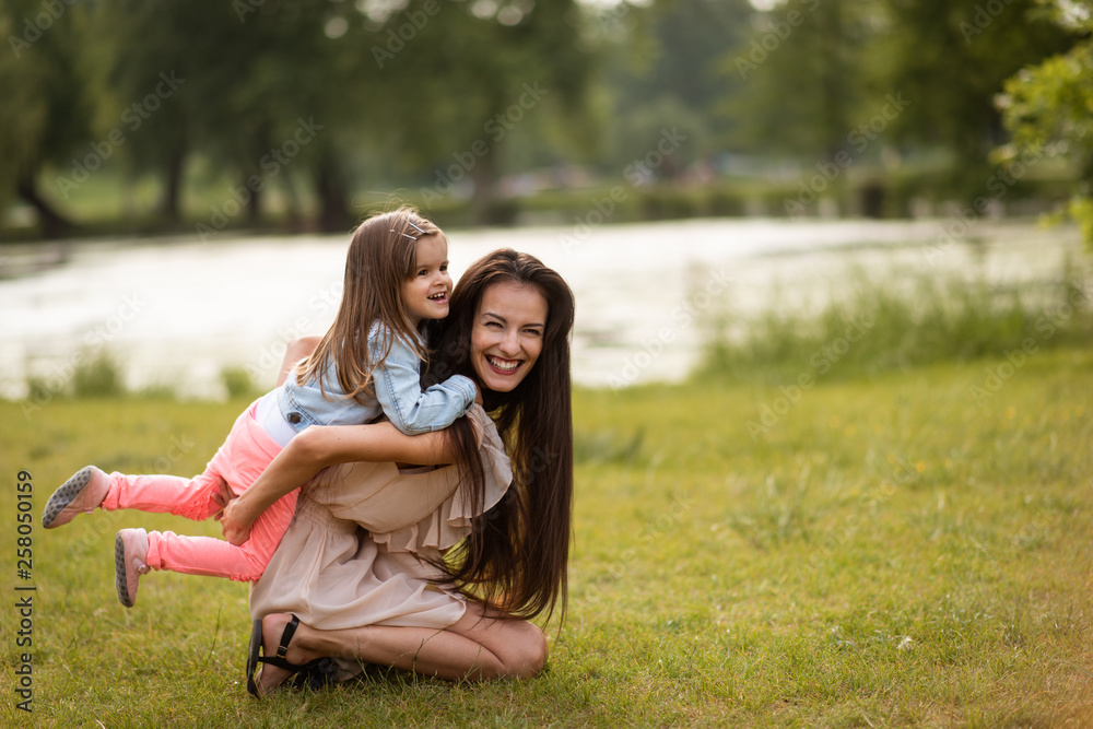 Young laughing woman with daughter in park Young laughing woman with daughter in park
