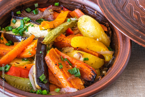 Vegetarian dish, homemade tajine or tagine with potatoes, eggplants, zucchini and pepper, close-up - traditional Moroccan and Tunisian cuisine photo