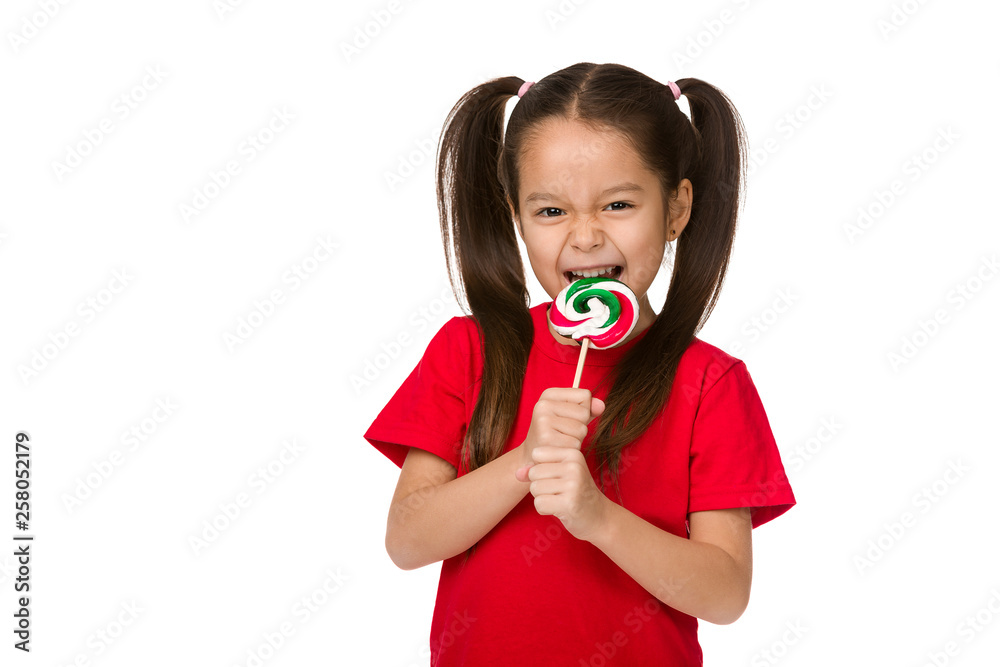 Beautiful cute little child girl eating sweet candy lollipop isolated on white background Beautiful cute little child girl eating sweet candy lollipop isolated on white background