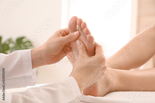 Young woman receiving feet massage in spa salon