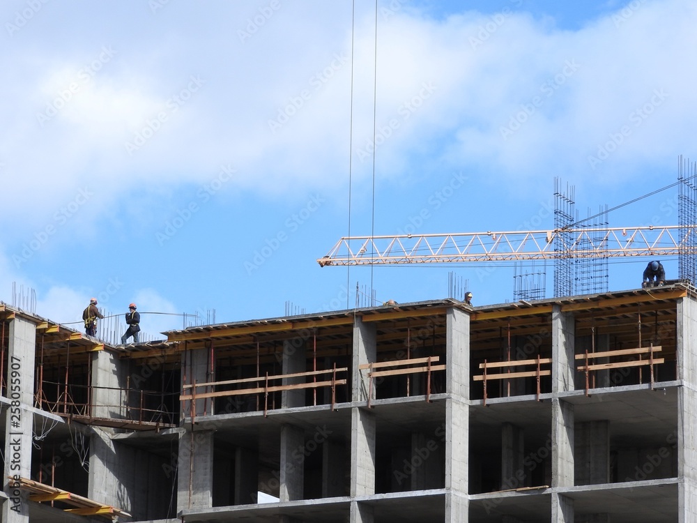 Large construction site, including several cranes working on the construction complex, with a clear blue sky. Large construction site, including several cranes working on the construction complex, with a clear blue sky.
