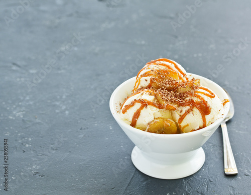vanilla ice cream with bananas and caramel in a bowl.