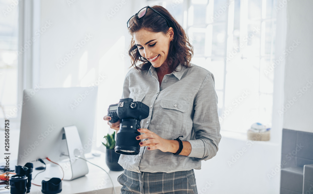 Female photographer checking pictures - obrazy, fototapety, plakaty 