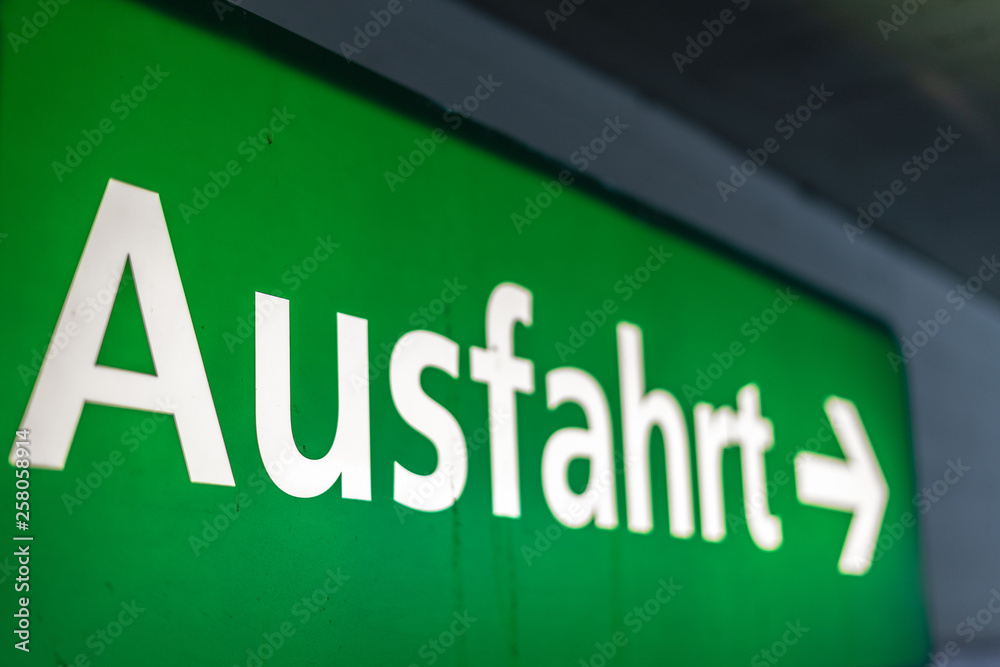 Beleuchtetes Hinweisschild Ausfahrt im Parkhaus, alt, dreckig und interessante Perspektive Beleuchtetes Hinweisschild Ausfahrt im Parkhaus, alt, dreckig und interessante Perspektive
