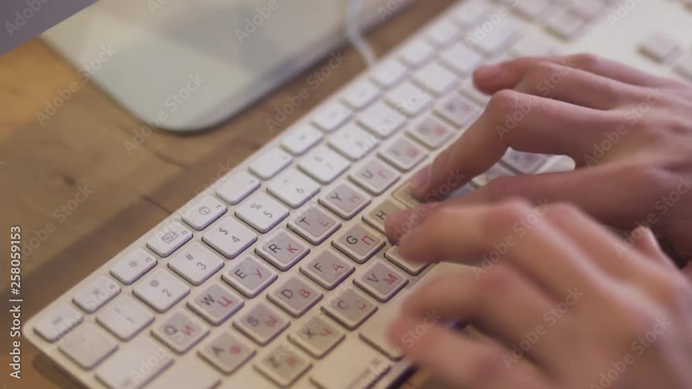 Man typing messages in chat and social networks or writing codes by the white keyboard. Close up Man typing messages in chat and social networks or writing codes by the white keyboard. Close up
