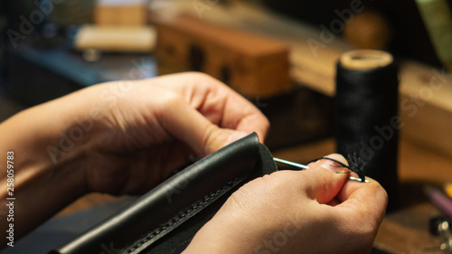 Leather handbag craftsman at work in a workshop