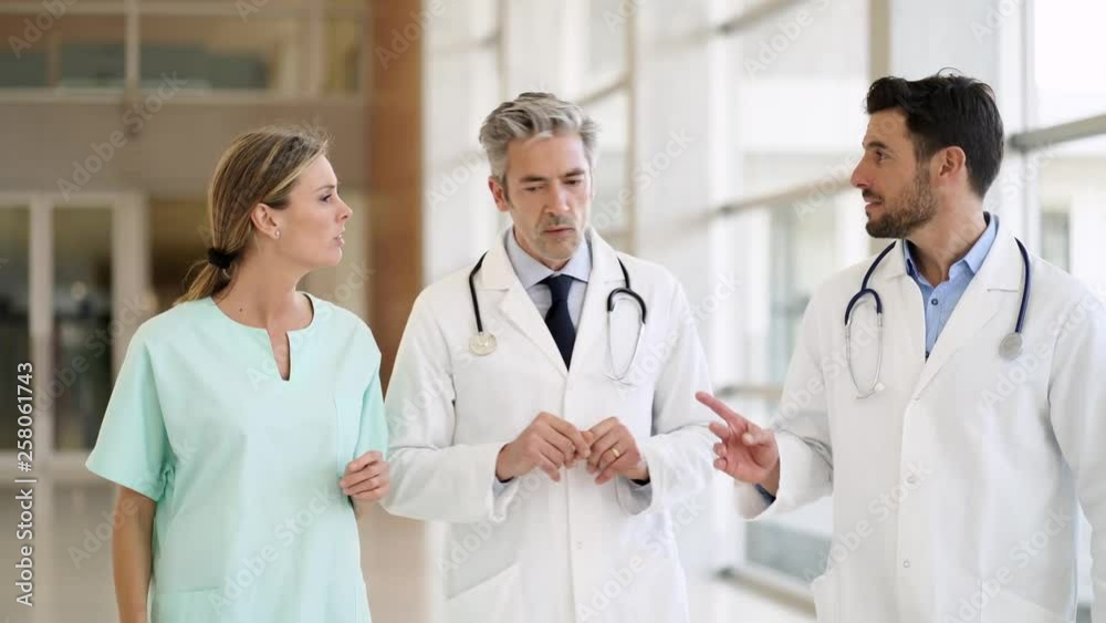 Doctors and nurse talking and walking in modern hospital Doctors and nurse talking and walking in modern hospital
