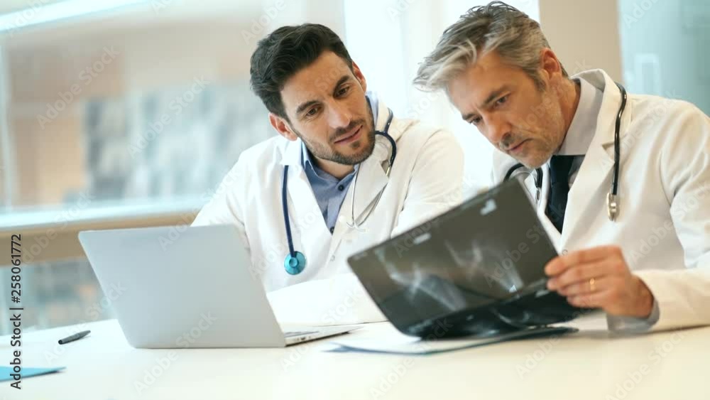 Team of doctors looking at X-Ray in hospital office Team of doctors looking at X-Ray in hospital office