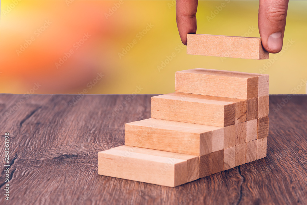 Man builds a wooden ladder. Concept: stable development