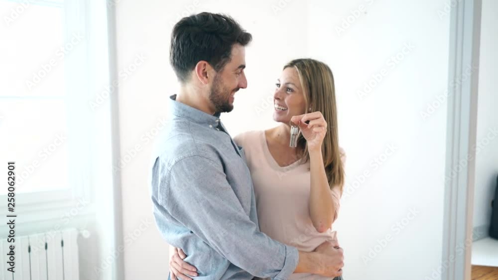 Happy new home owners in empty property with keys Happy new home owners in empty property with keys