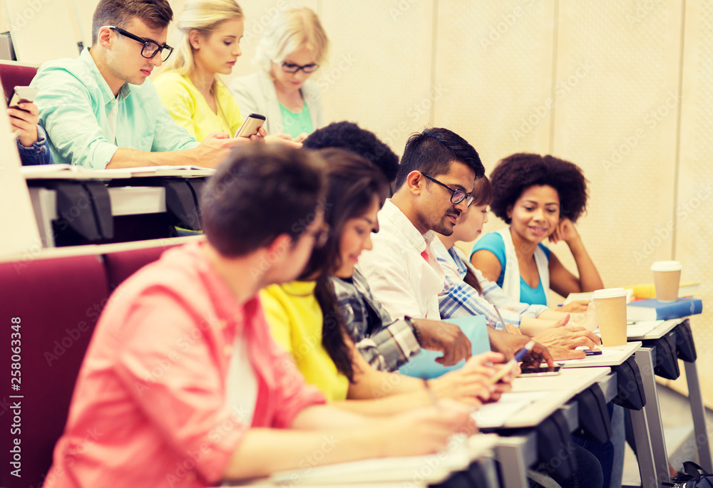 education, high school, university, learning and people concept - group of international students with notebooks and coffee writing test in lecture hall education, high school, university, learning and people concept - group of international students with notebooks and coffee writing test in lecture hall
