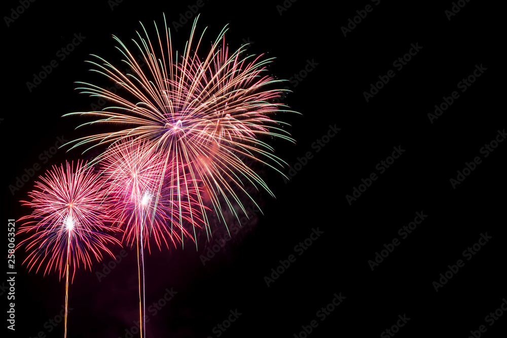 Amazing beautiful colorful fireworks display on celebration night, showing on the sea beach with multi color of reflection on water