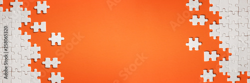 White details of puzzle on orange background photo