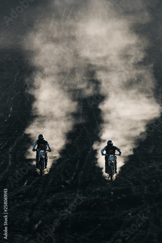 Obraz na plátne Two friends racing on custom retro style cafe racer black motorcycles on the bla
