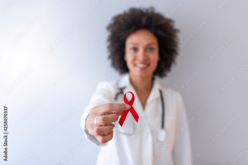 Female doctor with red ribbon. Cancer concept Female doctor with red ribbon. Cancer concept