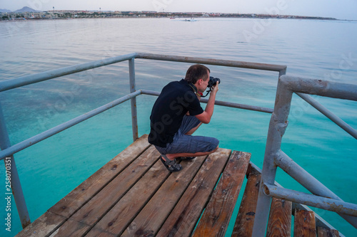 Obraz na płótnie man s photographing sea from a pier w salonie