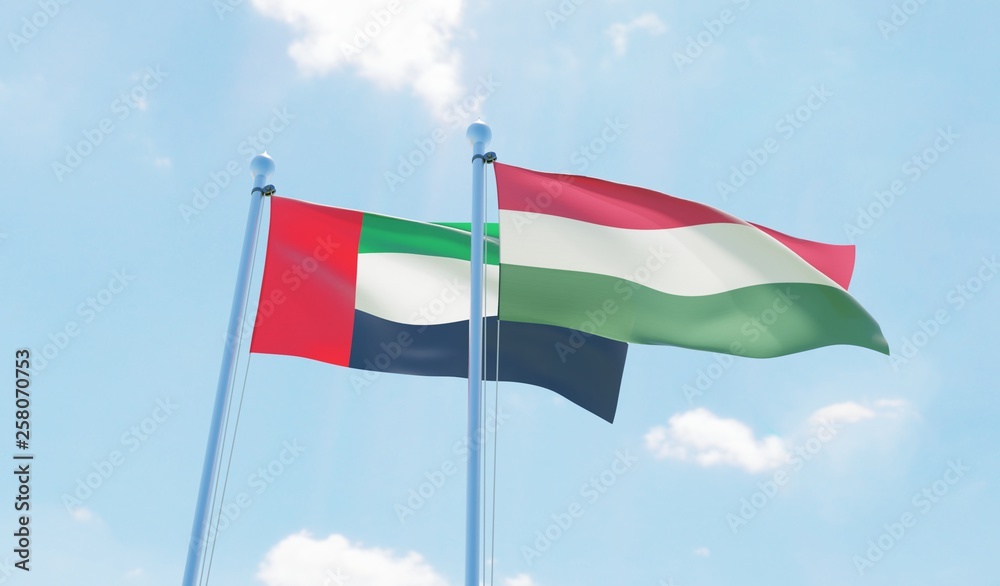Hungary and UAE, two flags waving against blue sky. 3d image Hungary and UAE, two flags waving against blue sky. 3d image