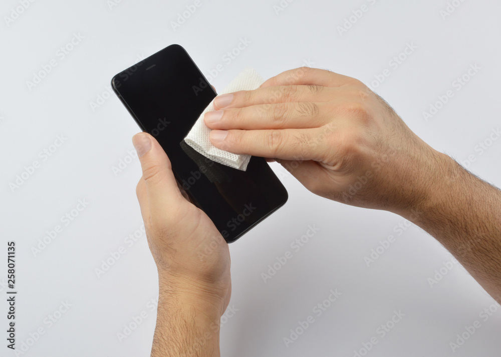 Man cleaning his smartphone with a microfiber cloth Man cleaning his smartphone with a microfiber cloth