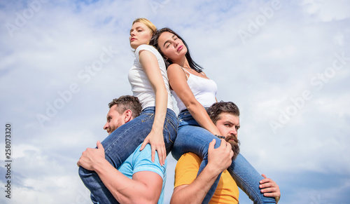 Couples in love having fun. Men carry girlfriends on shoulders. Summer vacation and fun. Couples on double date. Inviting another couple to join. Twice fun on double date. Friendship of families