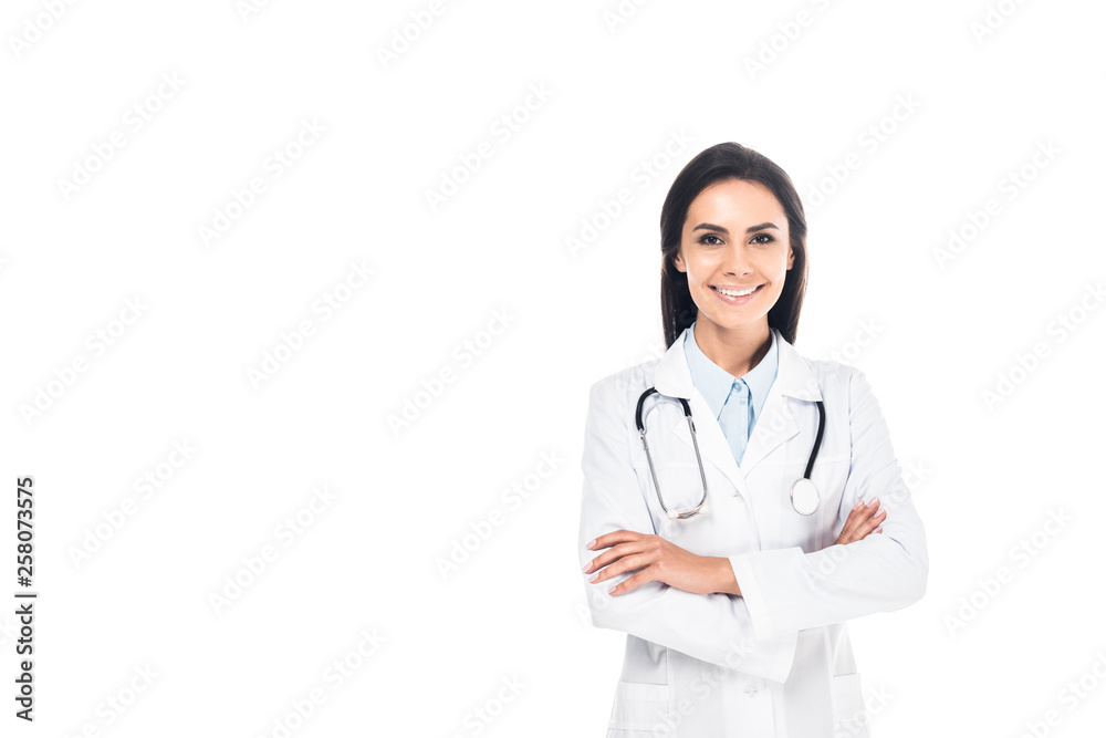 Smiling doctor in white coat standing with folded arms isolated on white Smiling doctor in white coat standing with folded arms isolated on white