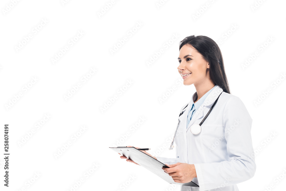 Smiling doctor in white coat holding clipboard isolated on white Smiling doctor in white coat holding clipboard isolated on white