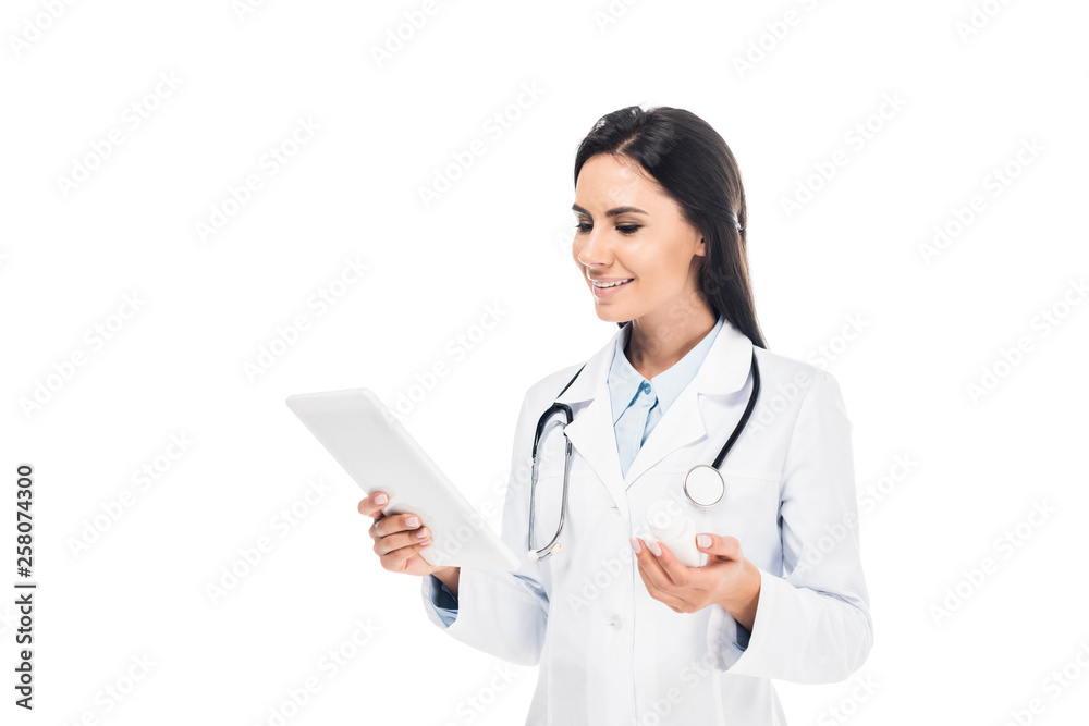 Doctor in white coat with stethoscope using digital tablet isolated on white Doctor in white coat with stethoscope using digital tablet isolated on white