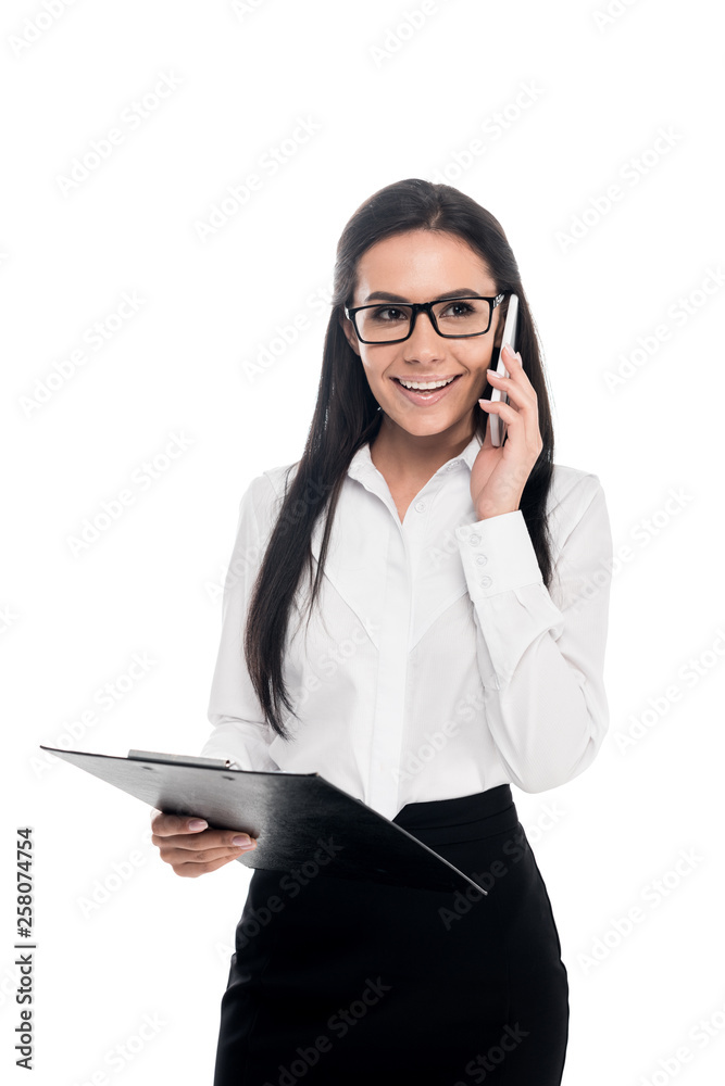 Businesswoman in glasses talking on smartphone and holding clipboard isolated on white