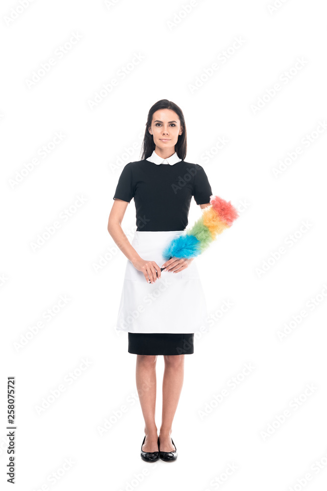 Full length view of brunette maid in uniform holding duster isolated on white Full length view of brunette maid in uniform holding duster isolated on white