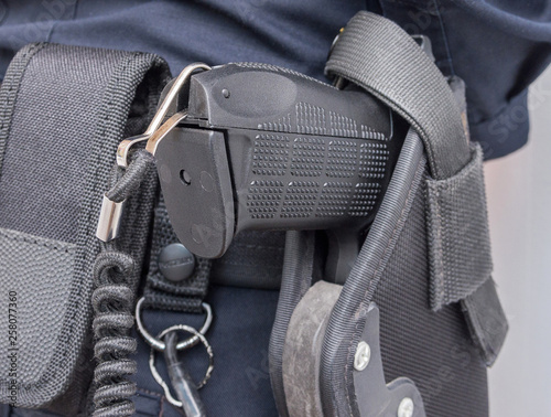 Patrol officer equipment: belt and gun. An armed police officer. 