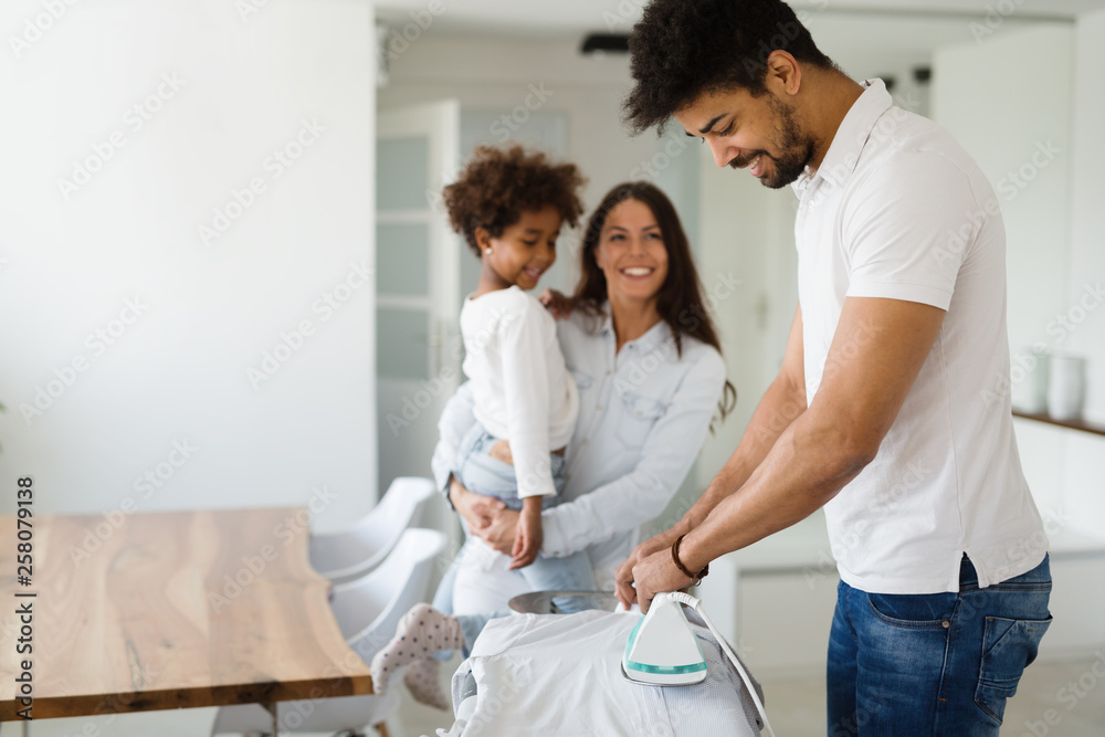 Obraz premium Young couple at home doing hosehold chores and ironing