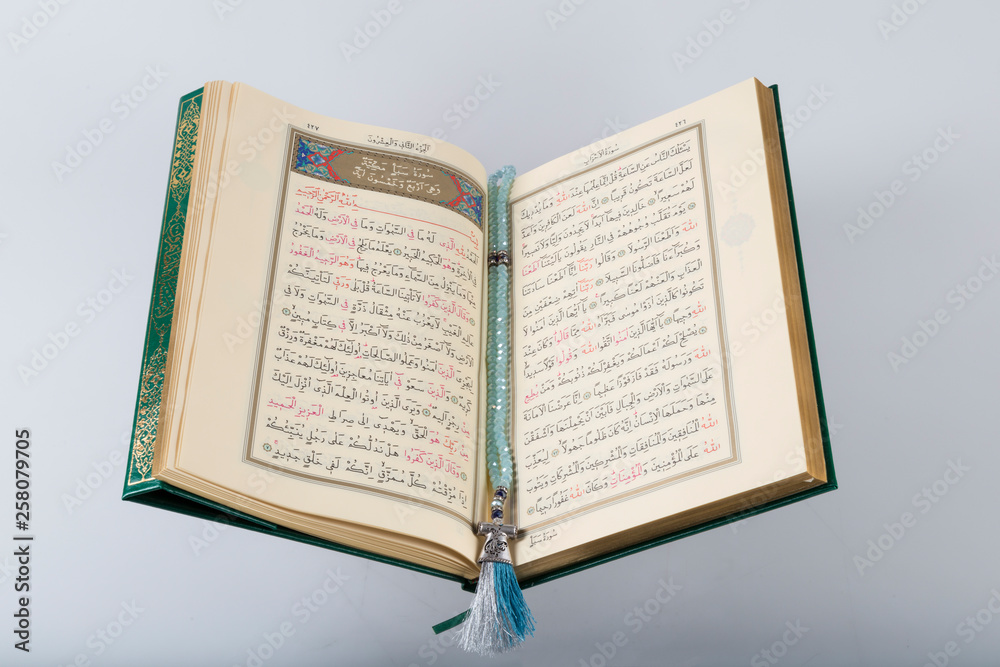 Fototapeta premium Quran and rosary beads on the wooden background with candle for Islamic concept. Holy book Koran for Muslims holiday, Ramadan,blessed Friday message