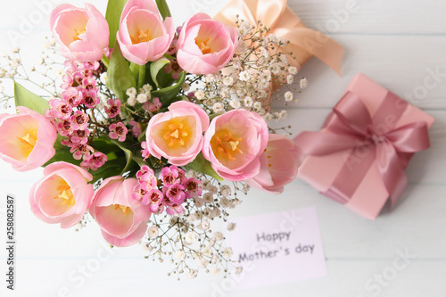  Beautiful composition for the Day of Mother on wooden background top view. Flowers  greeting card  gift.
