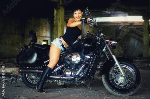 Strong independent   self-sufficient girl with male fascination on chopper motorcycle  international womens day concept