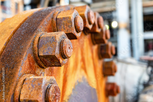 The cover of the old rusty heat exchanger covered with the same rusty bolts and nuts