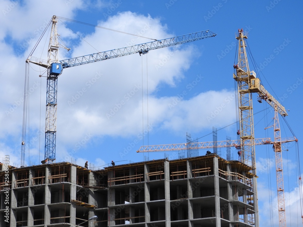 Large construction site, including several cranes working on the construction complex, with a clear blue sky. Large construction site, including several cranes working on the construction complex, with a clear blue sky.