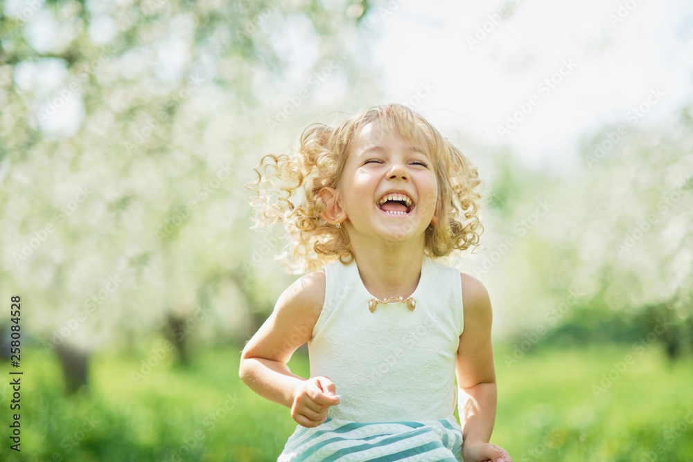 girl sniffing flowers of apple orchard. garden with flowering trees girl sniffing flowers of apple orchard. garden with flowering trees