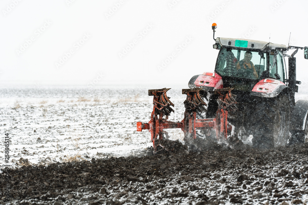 Obraz premium Plowing of stubble field during winter season