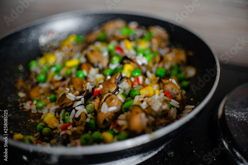 Fried frozen vegetable with rice and see food. Food remains in a black frying pan
