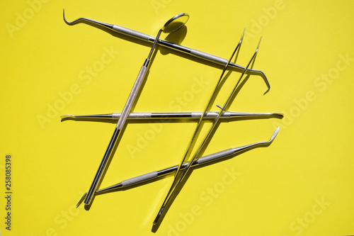 Tools for dental treatment on a yellow background